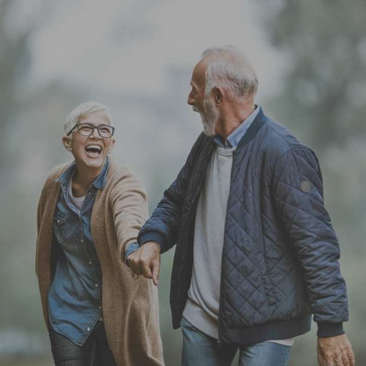 Older couple holding hands and laughing
